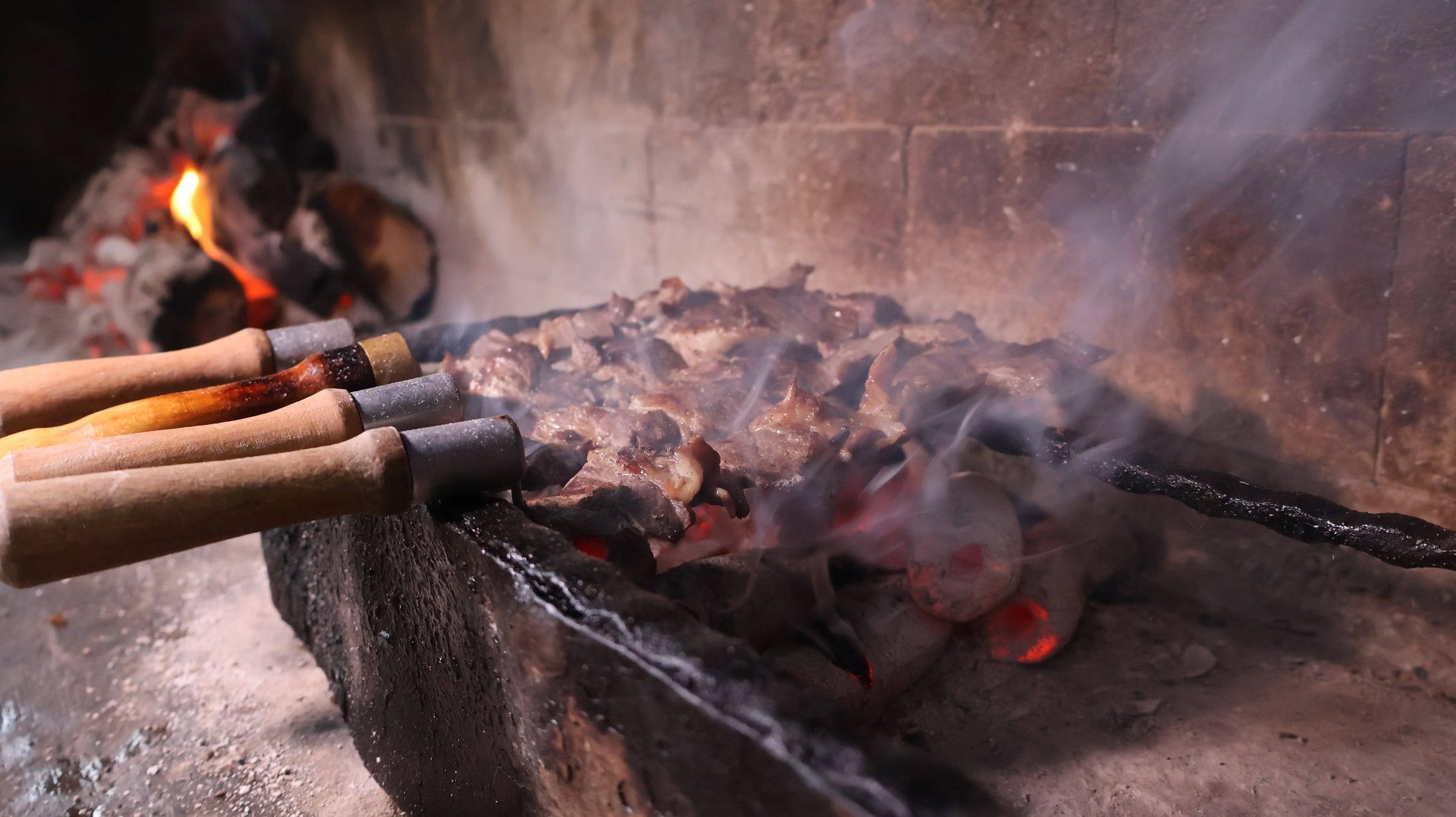 Carved cağ on thin skewers over the grill
